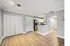 Interior of apartment. Brown and tan faux-wooded floors. Wall are light grey with white trimming and doors.