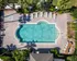 Stunning aerial view of a luxurious outdoor swimming pool surrounded by lush greenery and elegant lounge chairs on a stylish patio.