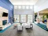 Luxurious and airy apartment living room with high ceilings, a stylish stone fireplace, contemporary seating, and abundant natural light.