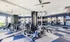 Contemporary fitness center featuring state-of-the-art exercise equipment and mirrored walls with a pool view.