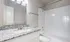 Sleek and modern bathroom with a granite countertop, large mirror, and elegant bathtub, offering a tranquil escape.