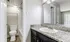 Elegant bathroom featuring modern fixtures, a granite countertop vanity, and warm wood flooring for a luxurious feel.