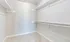 Spacious walk-in closet with ample shelving and soft carpeting, perfect for organizing wardrobe essentials.