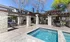 Inviting outdoor patio with elegant stone pillars, shaded seating areas, and a sparkling pool, perfect for relaxation.