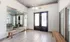 Bright and modern apartment entryway with elegant lighting, large glass doors, and chic tile flooring, offering a warm welcome with cozy seating.