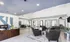 Modern apartment lobby featuring sleek leather chairs, vibrant artwork, and a welcoming reception desk, bathed in natural light.