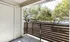 Charming balcony view with lush greenery and privacy-enhancing wooden railing, perfect for relaxation.