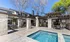 Luxurious poolside oasis with elegant stone pergola and modern outdoor seating, perfect for relaxation and entertaining.