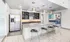 Modern kitchen with sleek stainless steel appliances, a spacious granite island, and elegant lighting fixtures, perfect for social gatherings.