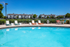 Inviting outdoor pool with stylish lounge chairs set against a backdrop of modern apartment buildings, perfect for relaxation and leisure.