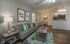 Contemporary living room with sleek furniture, colorful accents, and open kitchen dining area, exuding modern elegance and comfort.