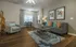 Inviting living area with modern decor, showcasing a stylish gray sofa with vibrant cushions, a chic armchair, and an elegant workspace by the window.