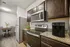 Elegant kitchen featuring dark wooden cabinets, modern appliances, and a cozy dining area with stylish seating.