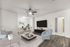 Modern living space with elegant furnishings, featuring a cozy sofa, stylish armchair, and large TV. Bright office area with natural light, complemented by sleek hardwood floors and minimalist decor.