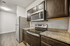 Modern kitchen with granite countertops, stainless steel appliances, and rich wood cabinetry in a bright, spacious layout.