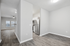 Modern apartment interior featuring an open-concept layout with sleek hardwood flooring, stainless steel appliances in the kitchen, and ample natural light from large windows.