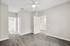 Bright, spacious room with elegant flooring, ceiling fan, and convenient access to a modern bathroom.