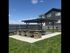 Charming outdoor patio with wooden pergola and stone picnic tables in a residential area.