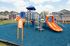Vibrant playground with colorful slides and climbing structures, set in a welcoming neighborhood backdrop.