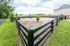 Charming outdoor space featuring a fenced area with fresh greenery and serene countryside views, perfect for relaxation.