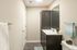 Modern bathroom featuring sleek dark wood cabinetry, elegant countertop sink, and contemporary decor with vibrant towels.