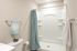 Elegant bathroom with modern fixtures featuring a sleek shower, chic blue curtains, and decorative accents.