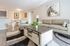 Inviting living room with a cozy beige couch, stylish armchair, and elegant coffee table, complemented by equestrian artwork and a dining area with rustic charm.