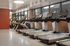 Modern gym with multiple treadmills and cardio machines, featuring sleek design and bright natural lighting.