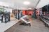 Modern fitness gym with state-of-the-art equipment, featuring free weights, weight machines, and bright spacious interiors.