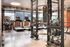 Modern and well-equipped apartment gym featuring treadmills, a weight rack, and a large punching bag in a stylish setting.