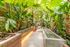 Lush green apartment atrium with tropical plants, illuminated walkways, and serene ambiance.