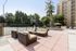 Chic outdoor patio with modern seating, surrounded by lush greenery and tennis court, perfect for relaxing and entertaining.