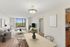 Bright and airy living room with a stunning window view, stylish sofa, modern decor, and adjacent dining area giving a sense of spaciousness.