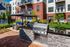 Chic apartment exterior with modern grill station and cozy patio seating, perfect for outdoor entertaining.