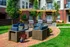 Charming outdoor patio featuring comfortable seating, modern grills, and lush greenery in a stylish communal space.