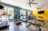 Bright and modern fitness center equipped with state-of-the-art treadmills and exercise bikes, featuring large windows and vibrant decor.