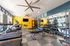 Bright, modern fitness center equipped with treadmills, weights, and stylish decor featuring large mirrors and vibrant colors.
