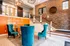 Welcoming lobby at Highland Station featuring elegant teal armchairs, warm wood accents, and a stylish stairway, setting a luxurious tone for the residence.