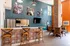 Modern apartment interior with stylish bar seating, contemporary decor, and vibrant orange and blue walls.