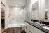 Luxurious bathroom with sleek marble tiles, modern double sink vanity, and a spacious walk-in shower.
