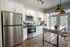 Modern kitchen with sleek stainless steel appliances, chic white cabinetry, and a stylish island featuring trendy wooden stools.