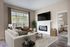 Inviting living room with cozy fireplace, large windows, modern furniture, and a glimpse into the elegant bedroom featuring soft lighting.