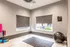 Bright and modern yoga room with large windows, elegant marble flooring, and exercise equipment.