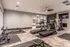 Modern apartment gym with sleek treadmills, weight racks, and stylish herringbone flooring, offering a luxury fitness experience.