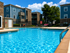 Inviting outdoor pool area surrounded by modern apartment buildings and lush greenery, perfect for relaxation and leisure in a vibrant community.