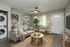 Chic and cozy living room with elegant gray sofa, accent chair, and indoor plant, complemented by a modern ceiling fan and natural light streaming through large window. Includes stackable washer and dryer for convenience.