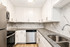 Sleek modern kitchen with stylish granite countertops, white cabinetry, stainless steel appliances, and elegant tile backsplash.