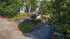 Charming gated community entrance surrounded by lush greenery and colorful flower beds.