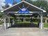 Inviting outdoor car care center with a spacious wash bay under a stylish roof, surrounded by greenery for a refreshing experience.