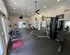 Bright, spacious gym with modern fitness equipment and large windows for a refreshing workout experience.